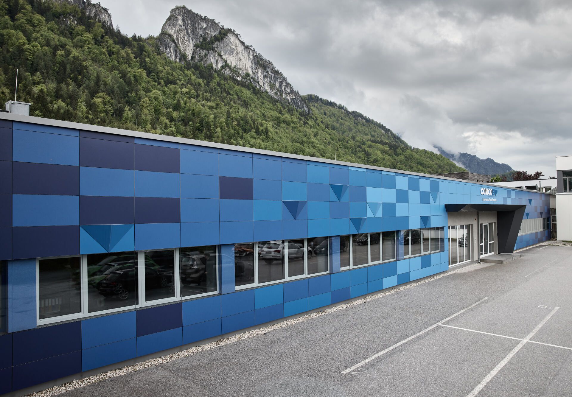 Ein blaues Gebäude mit Bergen im Hintergrund