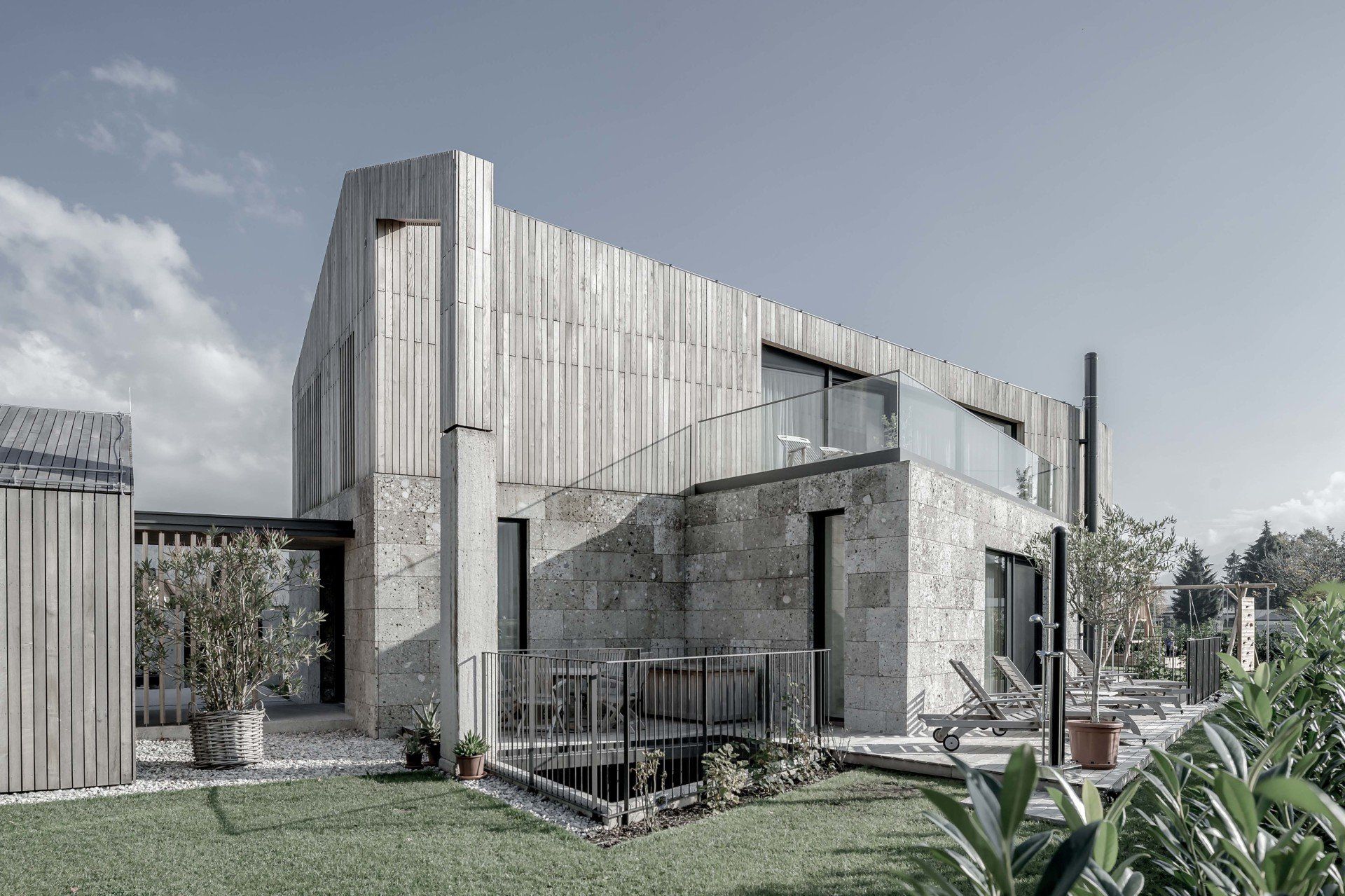 Ein großes Steinhaus mit Holzdach ist von einem üppigen grünen Rasen umgeben.