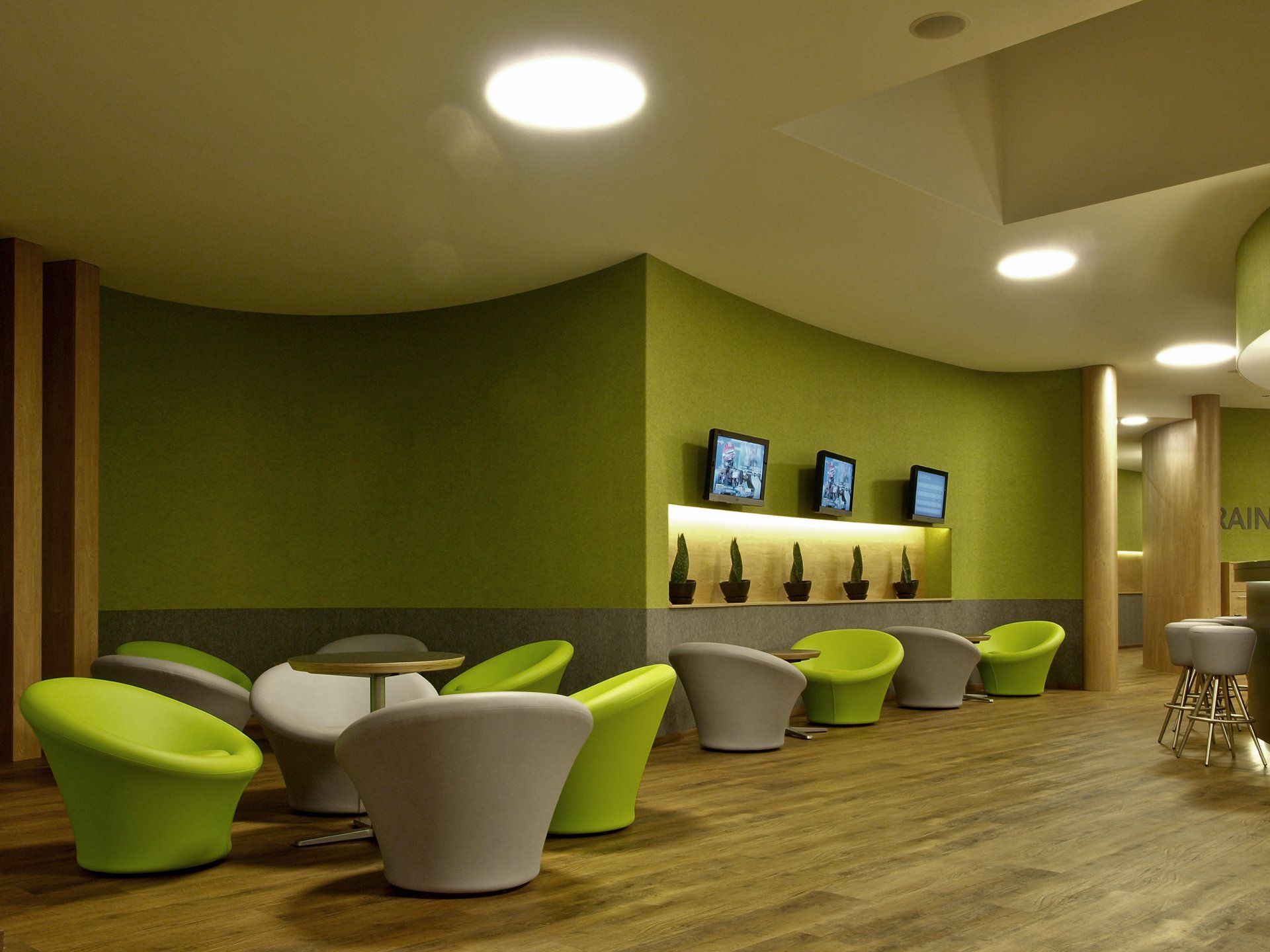 Eine Reihe grüner Stühle und Tische in einem Raum