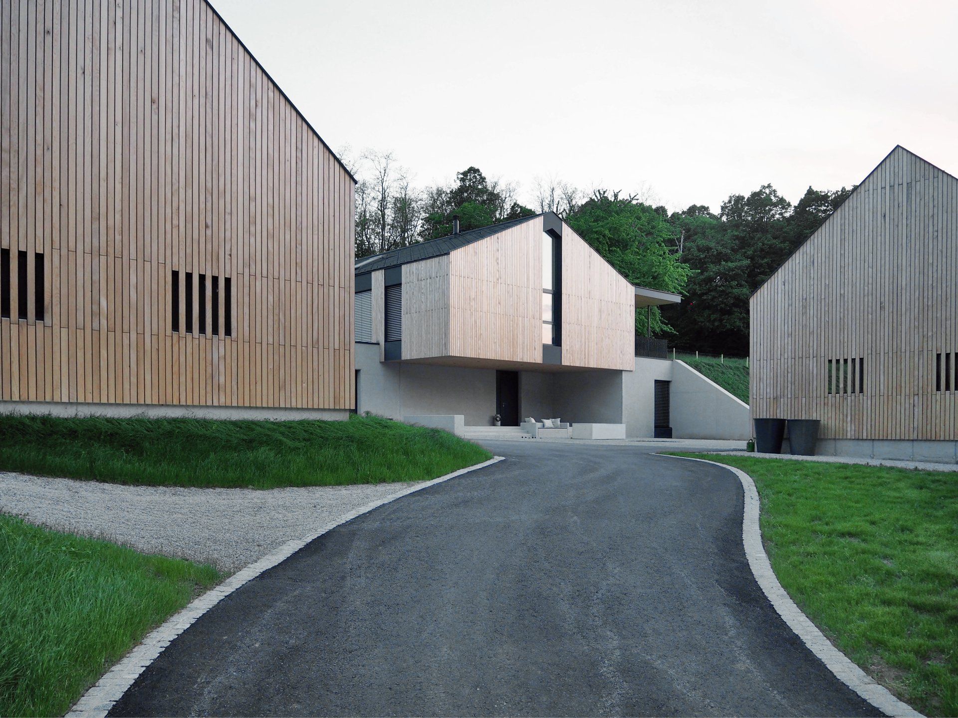 Eine Straße, die zu einem Haus mit einer Holzfassade führt