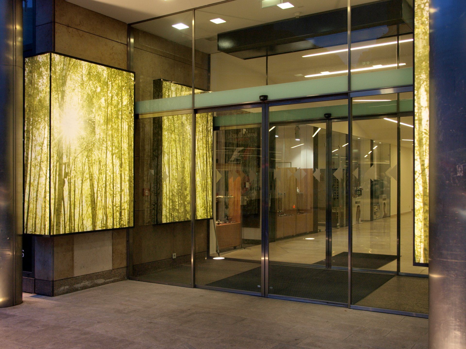 Ein Gebäude mit einer Glasschiebetür und einem Schild mit der Aufschrift „x“ darauf