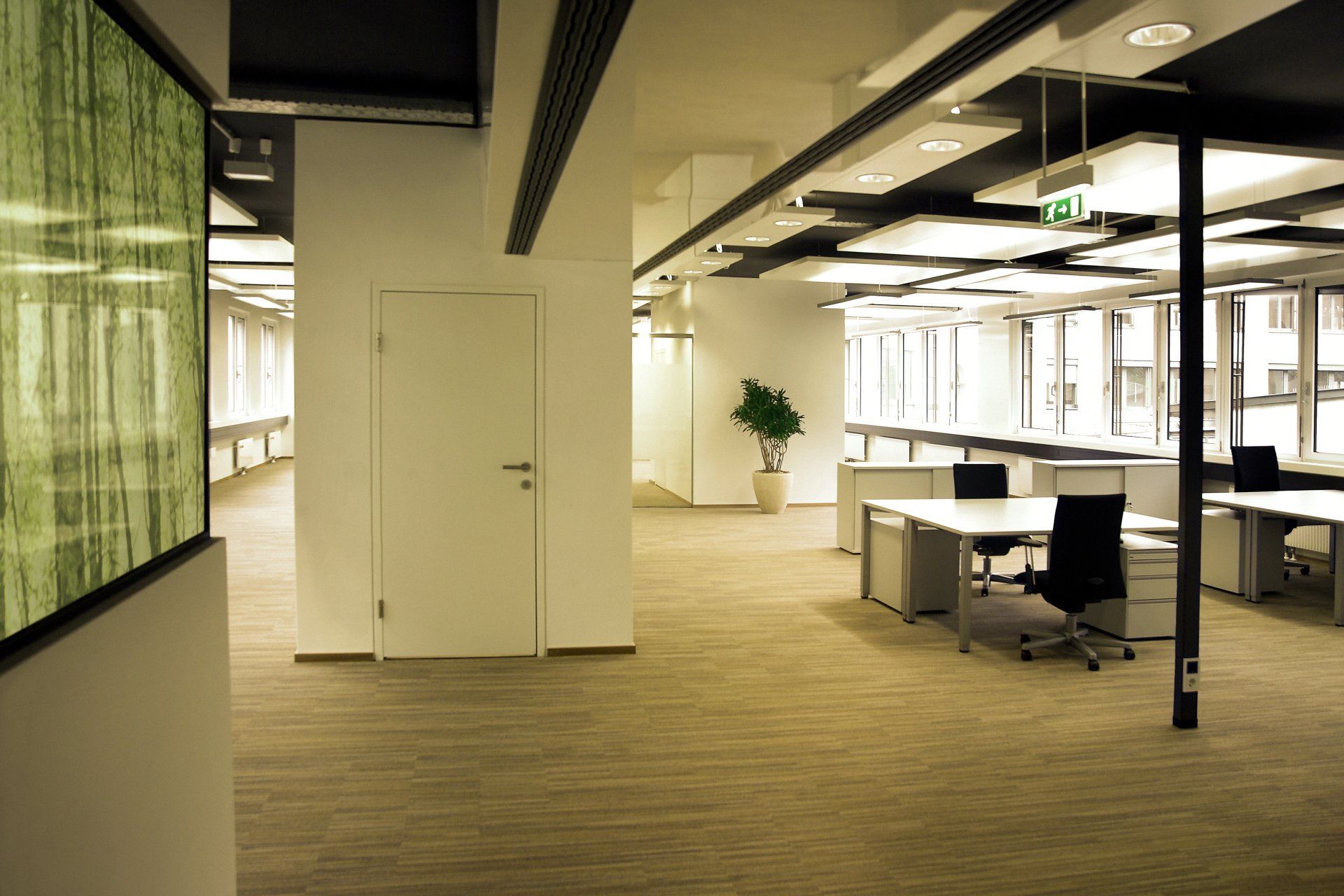 Ein leeres Büro mit einem grünen Notausgangsschild an der Decke