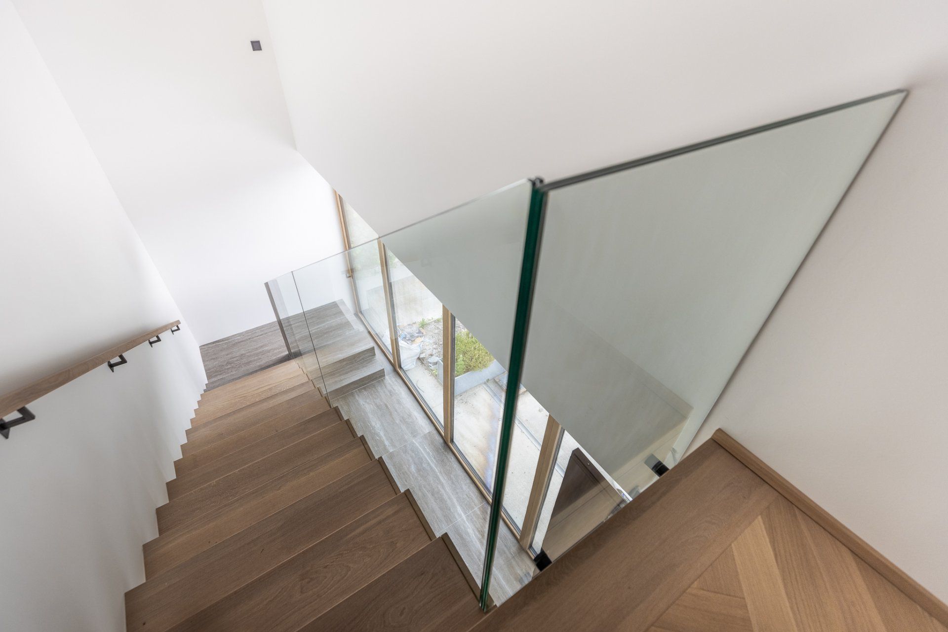Eine Holztreppe mit einem Glasgeländer in einem Haus