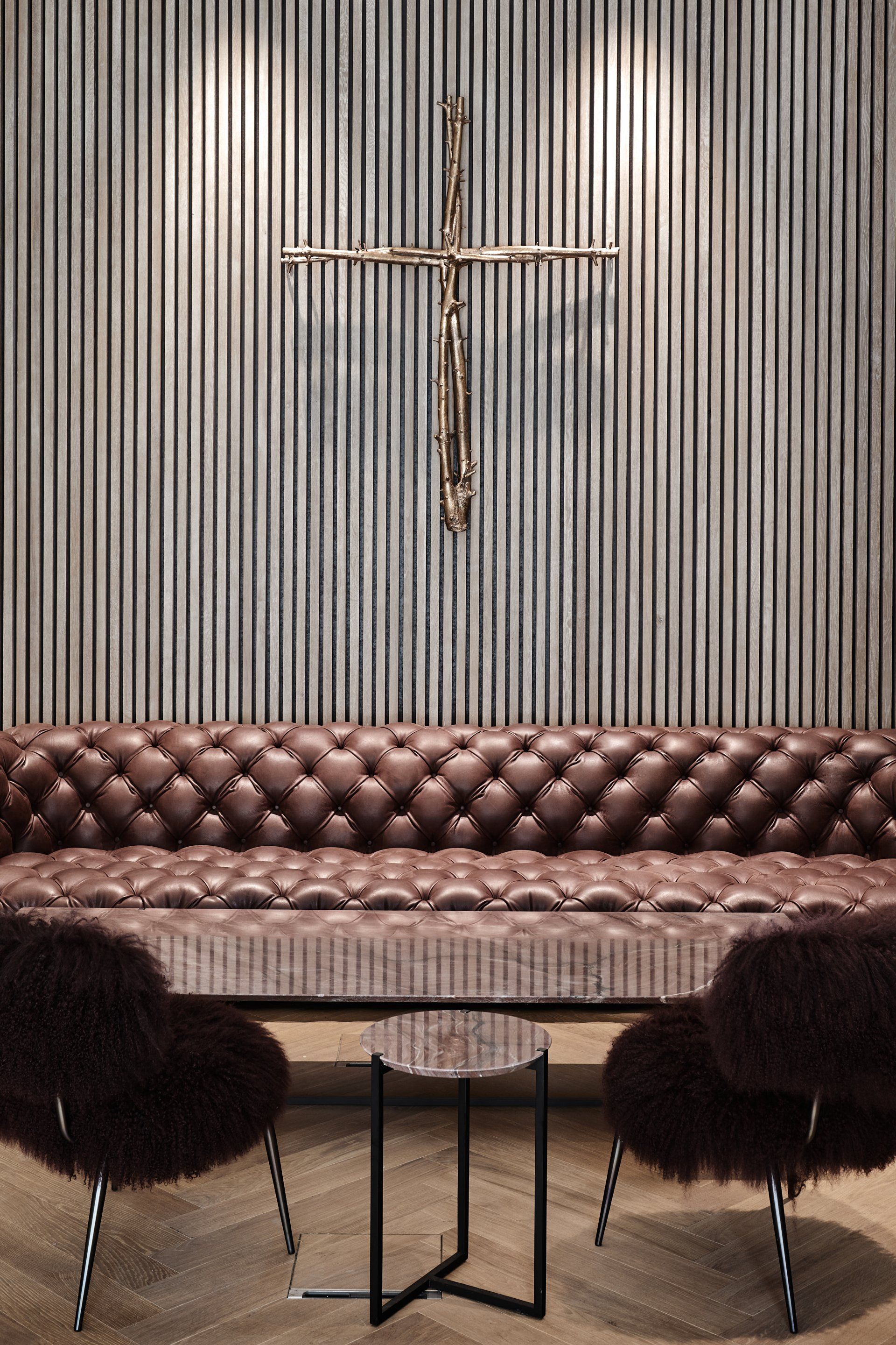 Ein Wohnzimmer mit einer Couch und Stühlen und einem Kreuz an der Wand