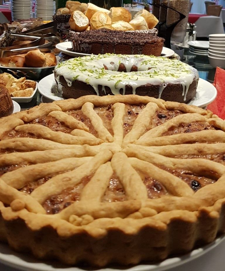 Uma torta em um prato com outras sobremesas ao fundo