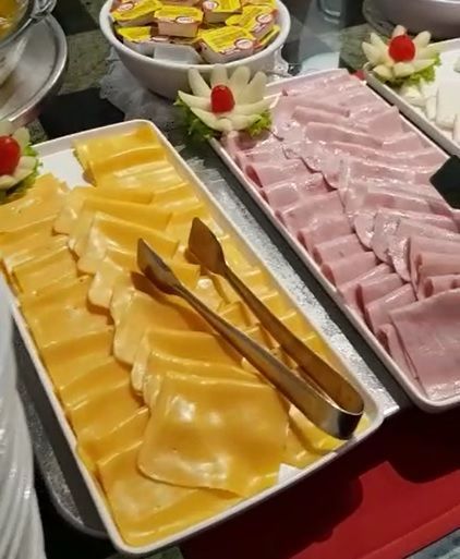 Várias bandejas de comida, incluindo queijo, presunto e pinças