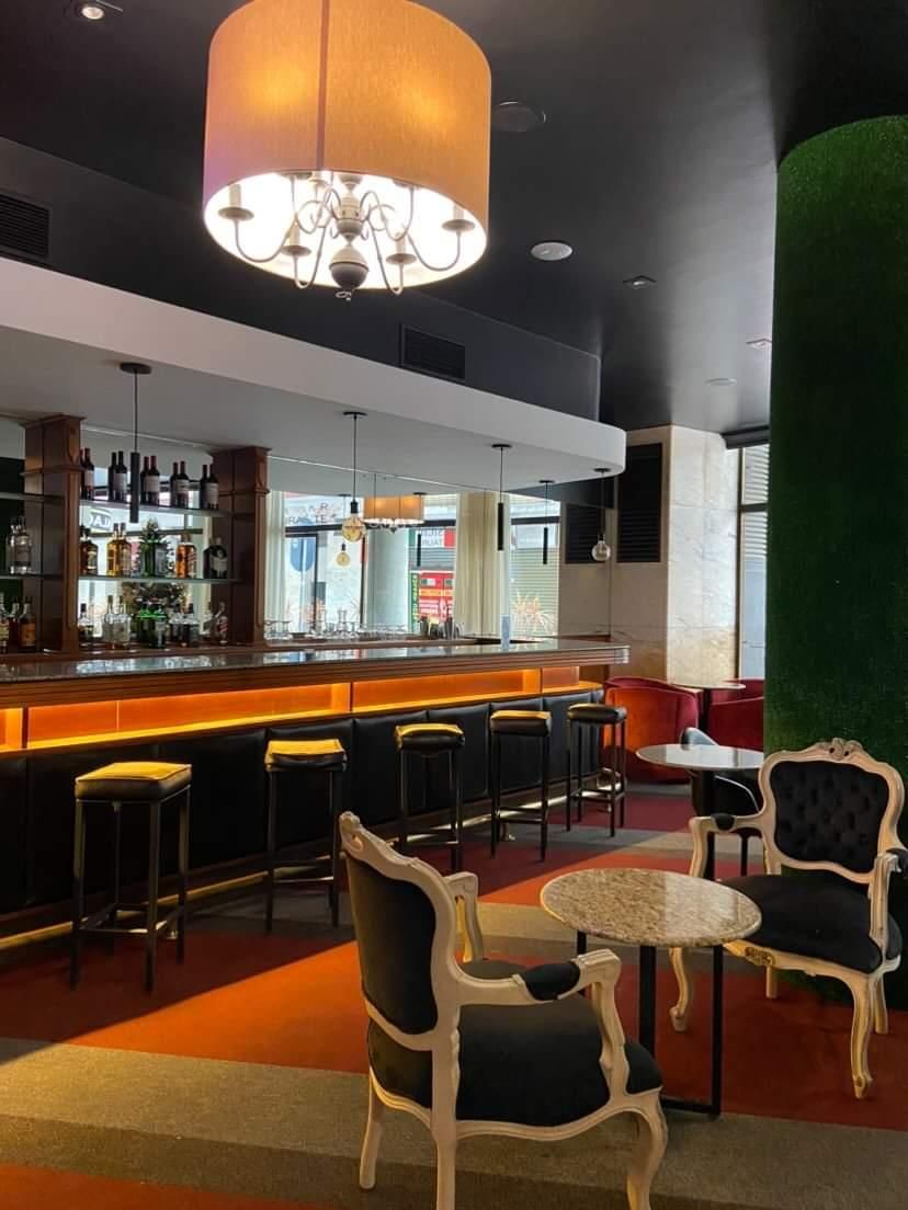 Um restaurante com mesas e cadeiras e um bar