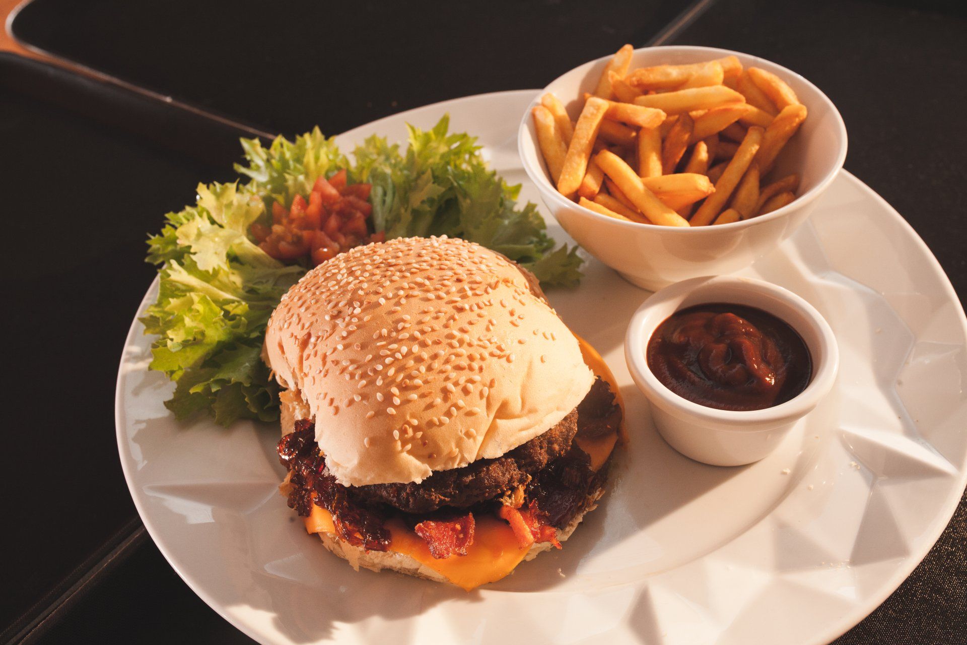 Um prato branco coberto com hambúrguer e batatas fritas