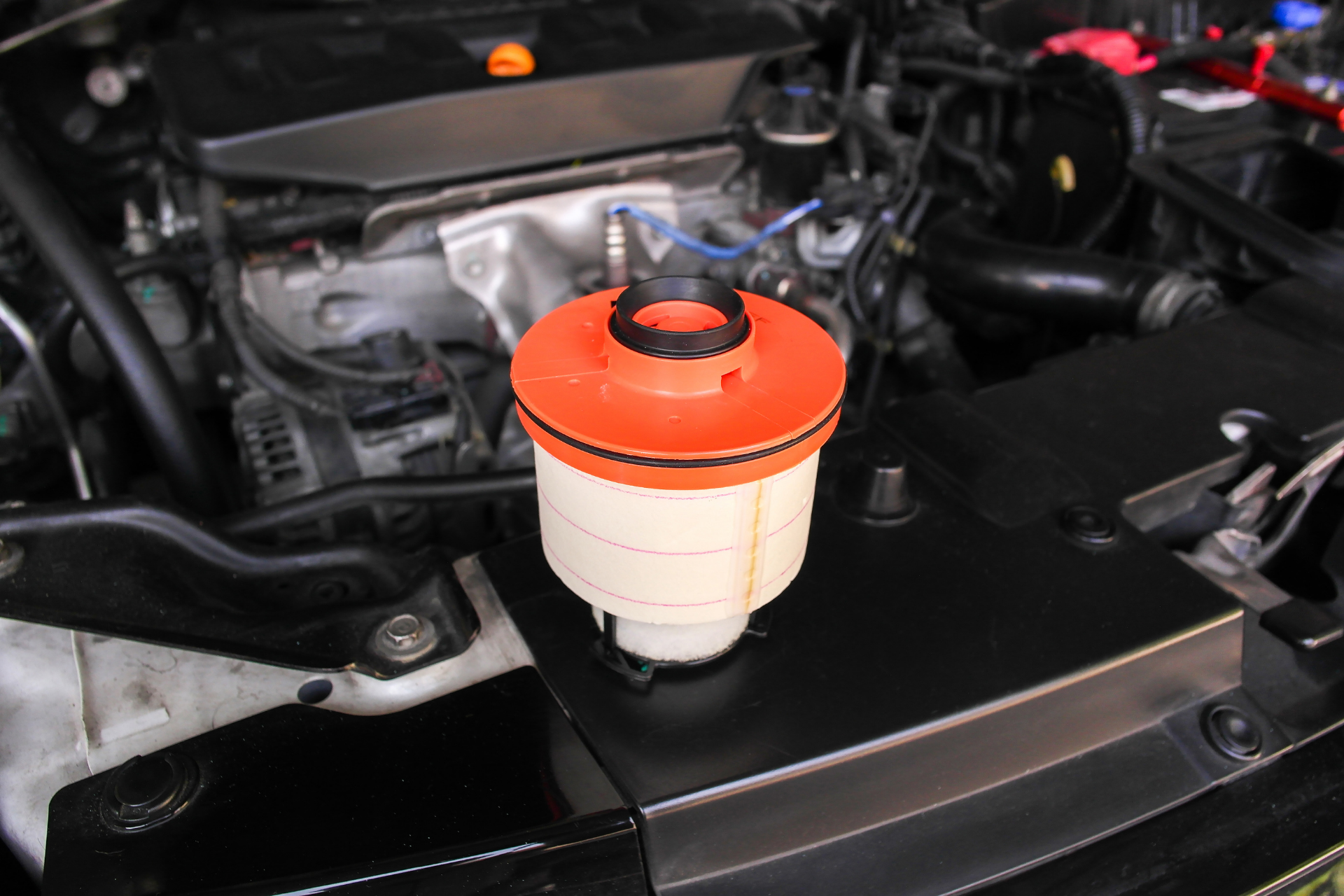 Orange and white power steering fluid reservoir on a car engine.