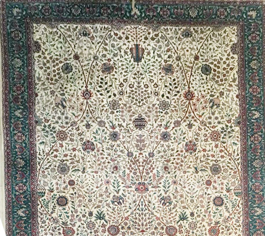 A rug with a floral pattern on it is hanging on a wall.