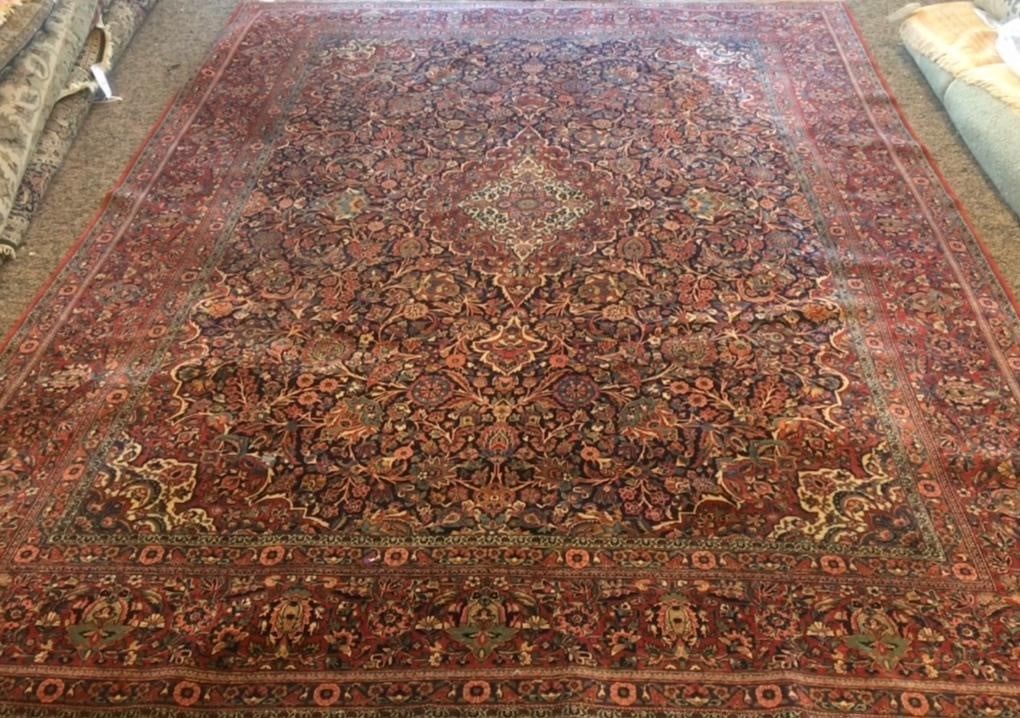 A large rug is sitting on top of a wooden floor.