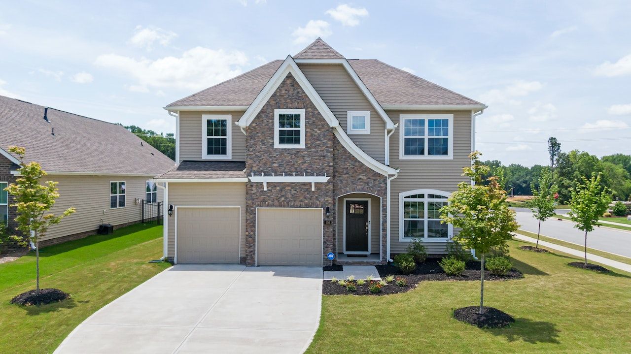 A large house with two garages and a driveway in a residential area.