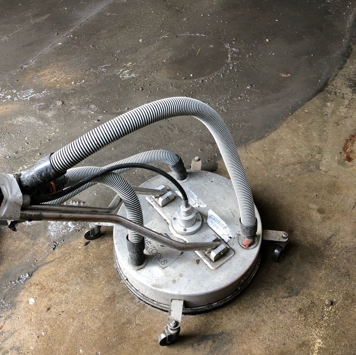 A machine with a hose attached to it is sitting on the ground.