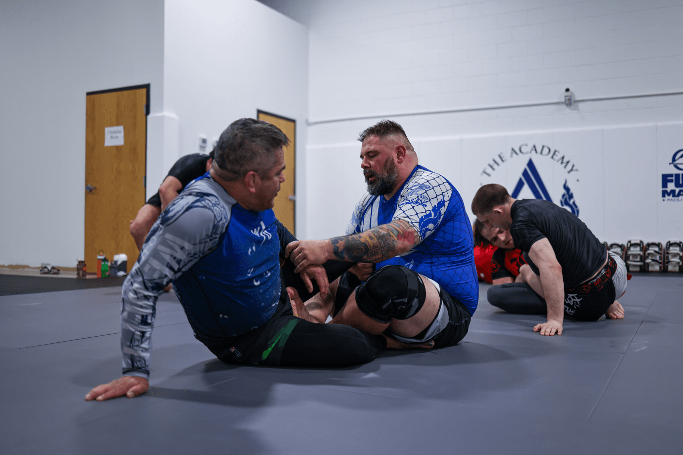Adults partner-drilling Brazilian Jiu-Jitsu at The Academy Eden Prairie in Minneapolis, MN.