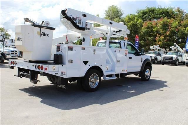 A white utility truck with a bucket on top of it
