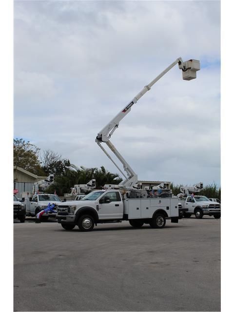 A white truck with a bucket on top of it