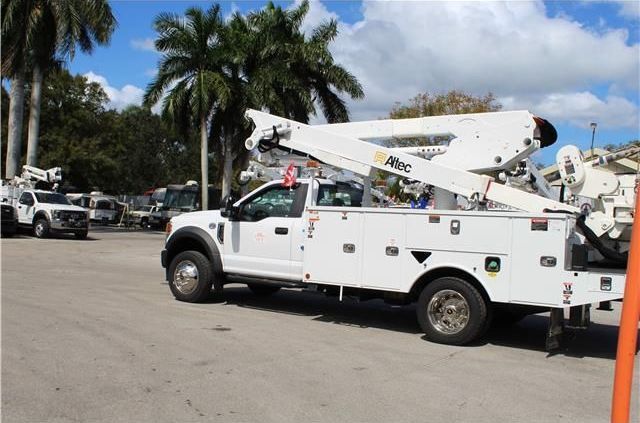 A white utility truck is parked in a parking lot