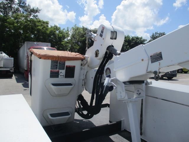 A white bucket truck is parked in a parking lot