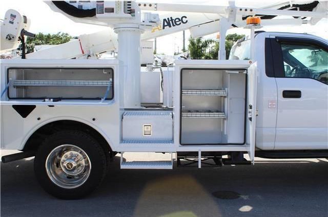 A white utility truck with a crane on top of it