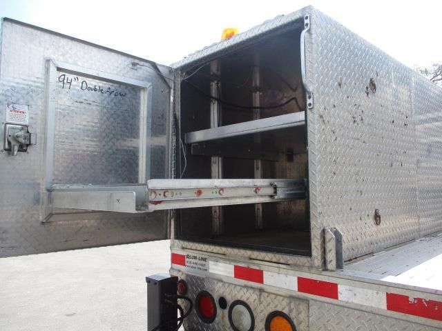 An aluminum trailer with the door open and shelves