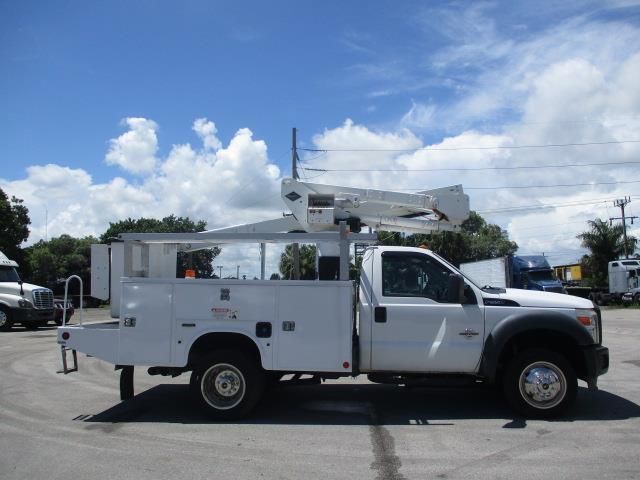 A white utility truck is parked in a parking lot