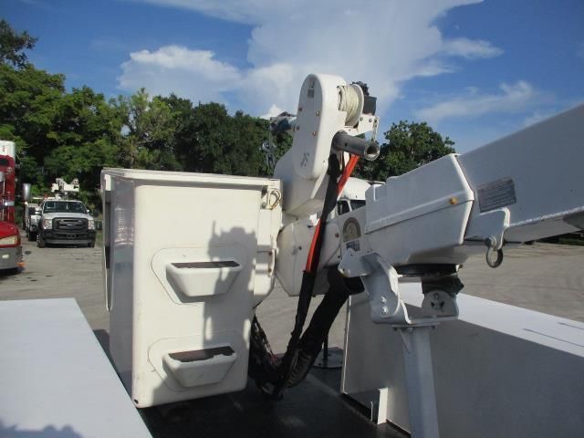 A white bucket truck is parked in a parking lot