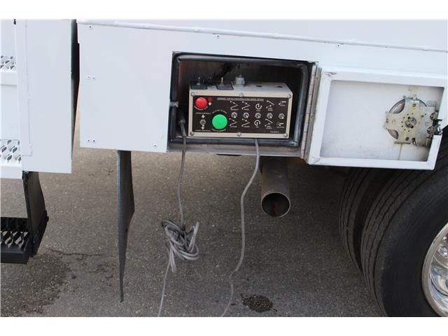 A box with a green button on the side of a truck