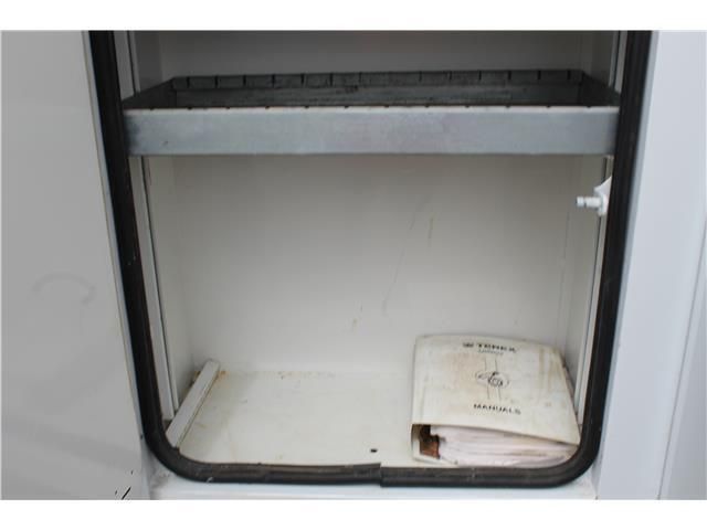 An empty shelf with a binder in it