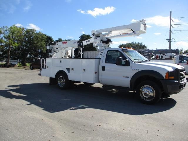 A white utility truck is parked in a parking lot
