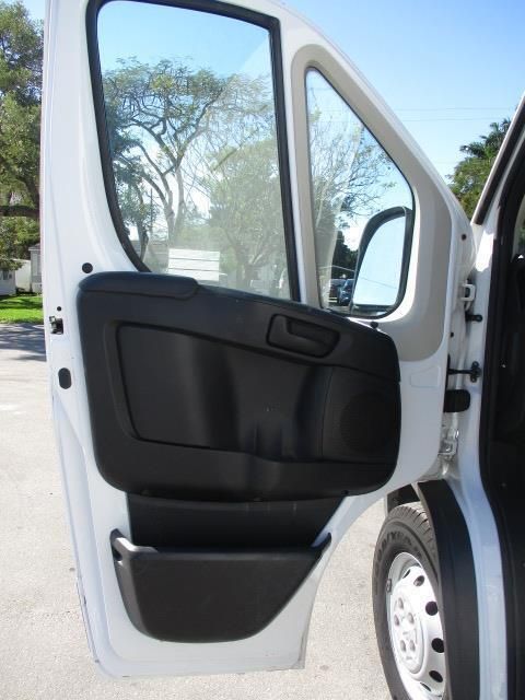 A white van with the door open and trees in the background