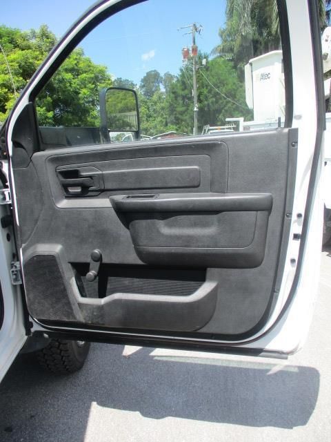 A white truck with the door open is parked in a parking lot
