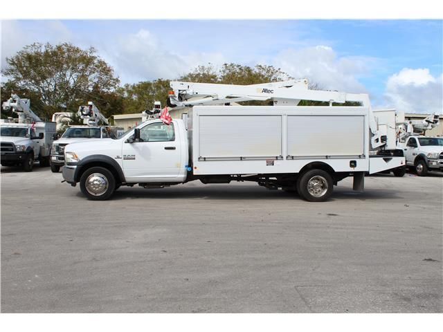 A white utility truck is parked in a parking lot.