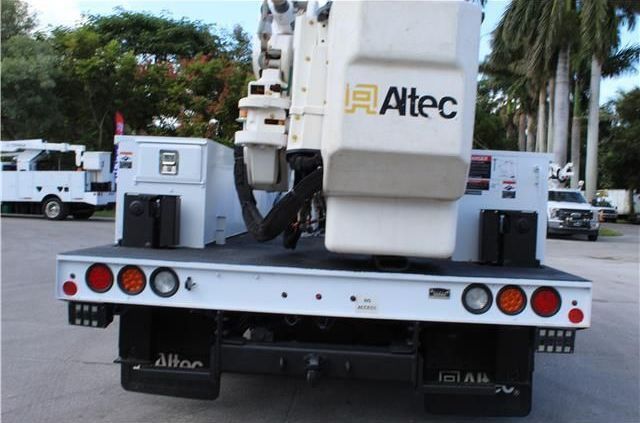 A white altec truck is parked in a parking lot