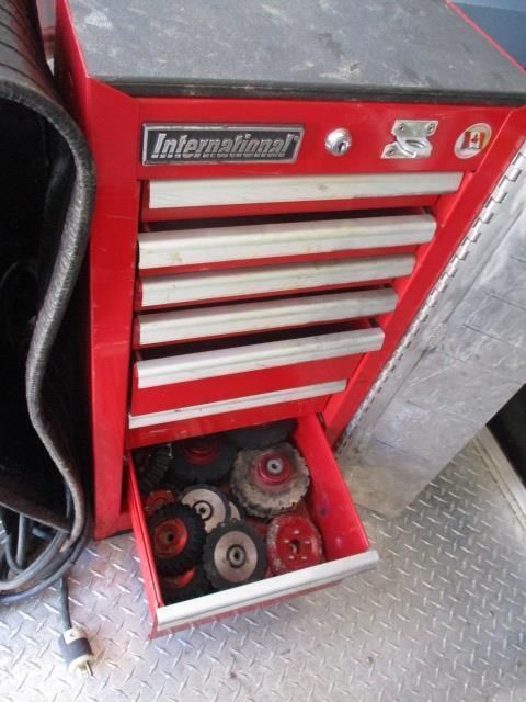 A red international toolbox with a drawer full of tools
