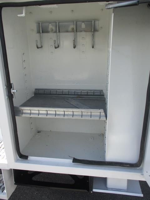 A white cabinet with a shelf and hooks on it