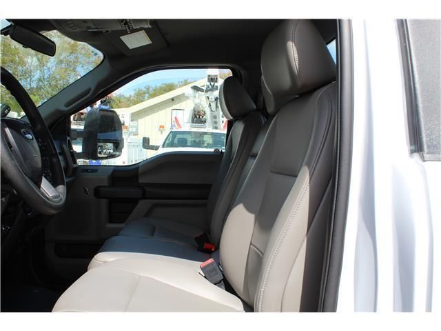 The inside of a white truck with a steering wheel and seats