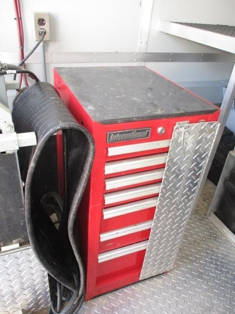 A red toolbox with a hose attached to it