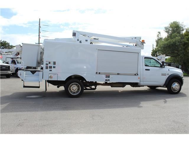A white utility truck is parked in a parking lot
