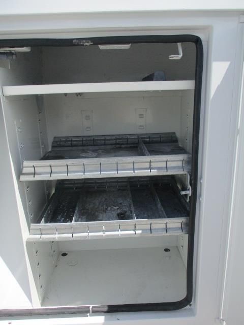 The inside of a white cabinet with shelves and drawers