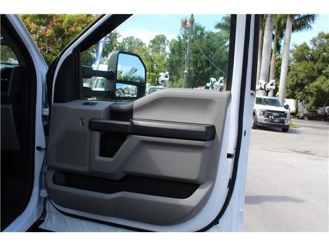 A white truck is parked in a parking lot with the door open