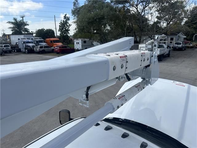 A white truck with a ladder attached to the hood