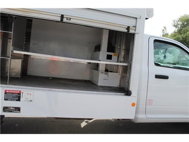 A white truck with the door open and shelves in the back