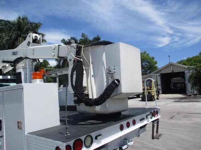 A white bucket truck is parked in a parking lot