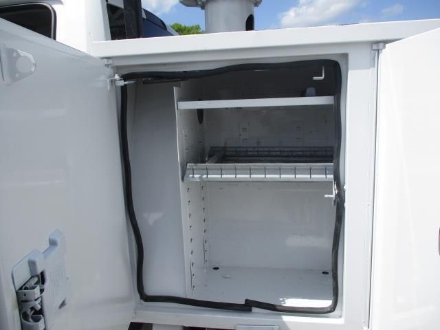 A white cabinet with the door open and a black hose coming out of it.