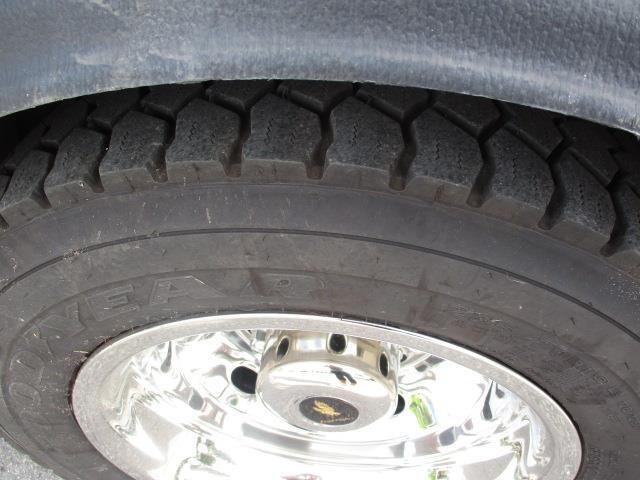 A close up of a tire on a car with a chrome rim