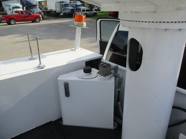 A white truck with a red truck in the background