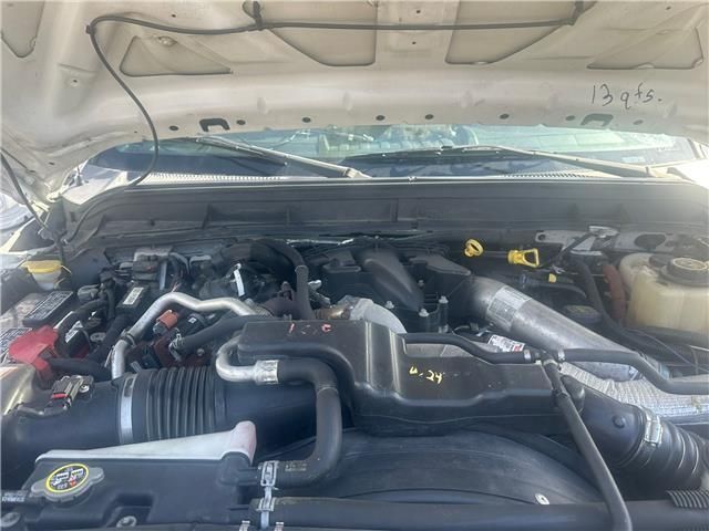 The engine of a white truck is shown with the hood open