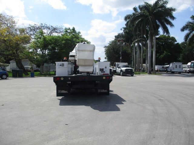 A truck is parked in a parking lot with palm trees in the background