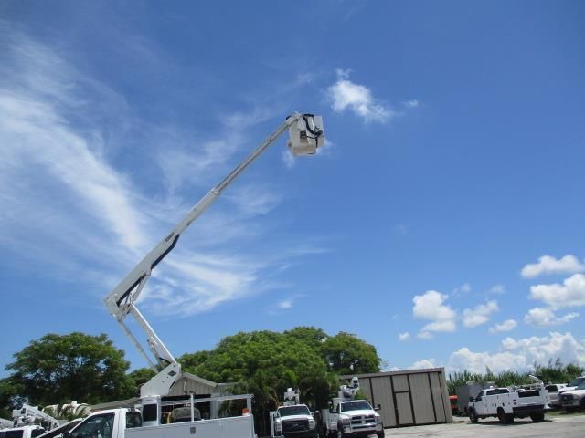 A bucket truck is parked in a parking lot with a blue sky in the background