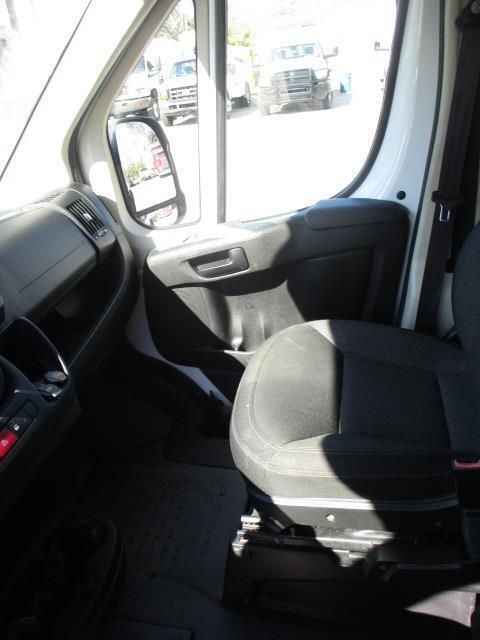 The inside of a white van with a black seat